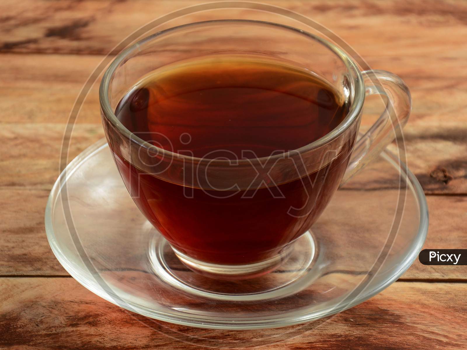 Freshly Brewed Darjeeling Black Tea In Glass Cup On Rustic Wooden Background, Selective Focus