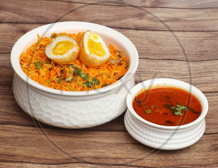 Egg Biryani - Basmati Rice Cooked With Masala And Spices And Served With Sliced Boiled Eggs And Brinjal Curry, Selective Focus