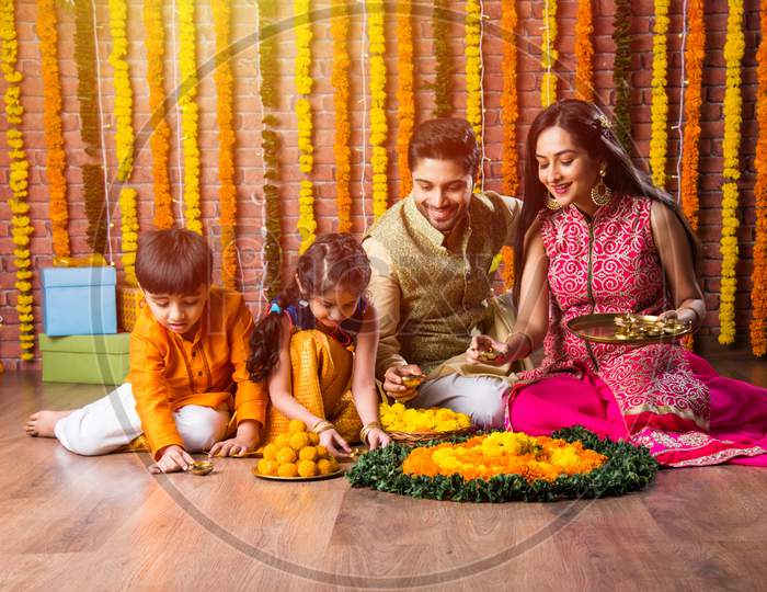 Indian Family Together Arranging Oil Lamp Or Diya For Diwali Festival Celebrations