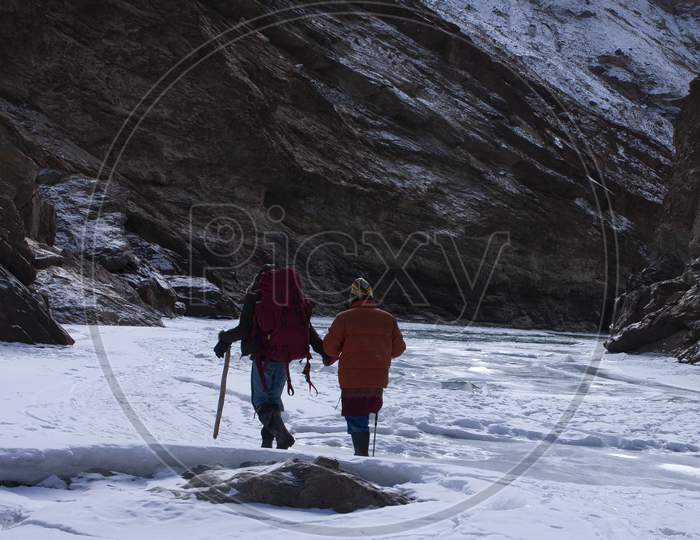 Adventurous High Altitude Trekking On The Frozen Zanskar River [ Known As Chadar Trek ] In Winter In Ladakh In India Carrying Rucksack And Walking Stick