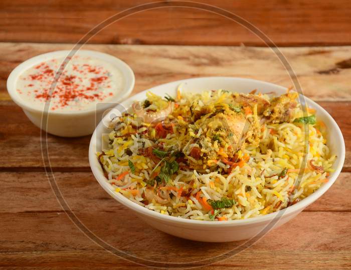 Traditional Hyderabadi Chicken Dum Biryani Made Of Basmati Rice Cooked With Masala Spices, Served With Yogurt, Selective Focus