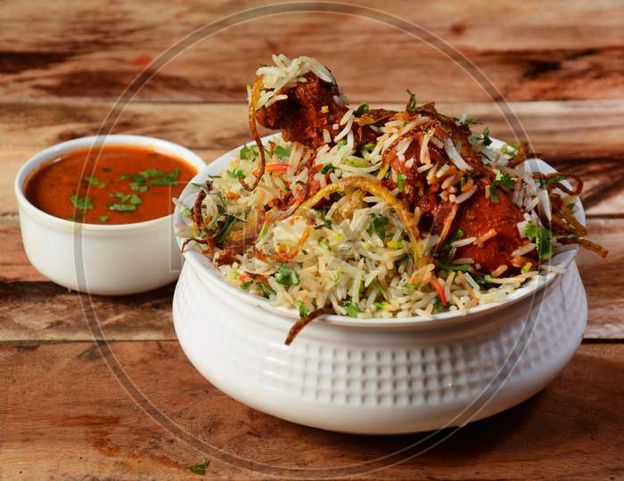 Traditional Hyderabadi Chicken Dum Biryani Made Of Basmati Rice Cooked With Masala Spices, Served With Salan, Selective Focus