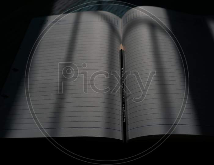 Notebook in middle pencil for writing the thought and quote