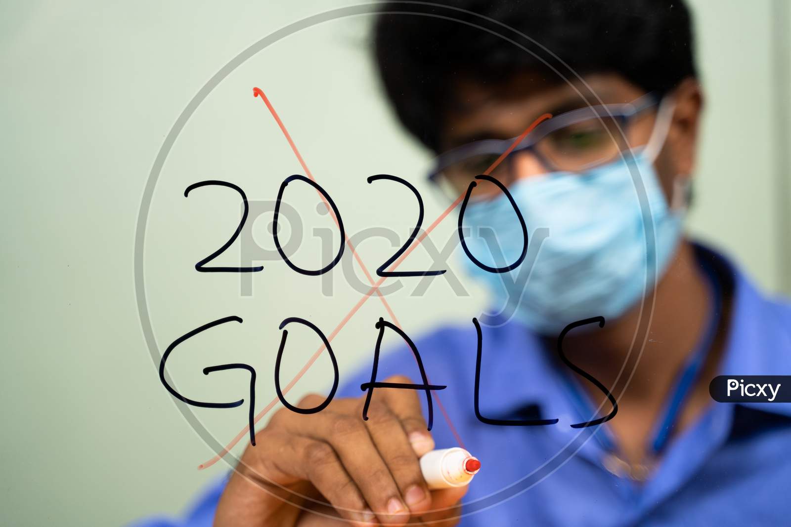 Young Man In Medical Mask Scratching Out 2020 Goals Due To Coronavirus Or Covid-19 Pandemic - Concept Of Failed 2020 Goals.