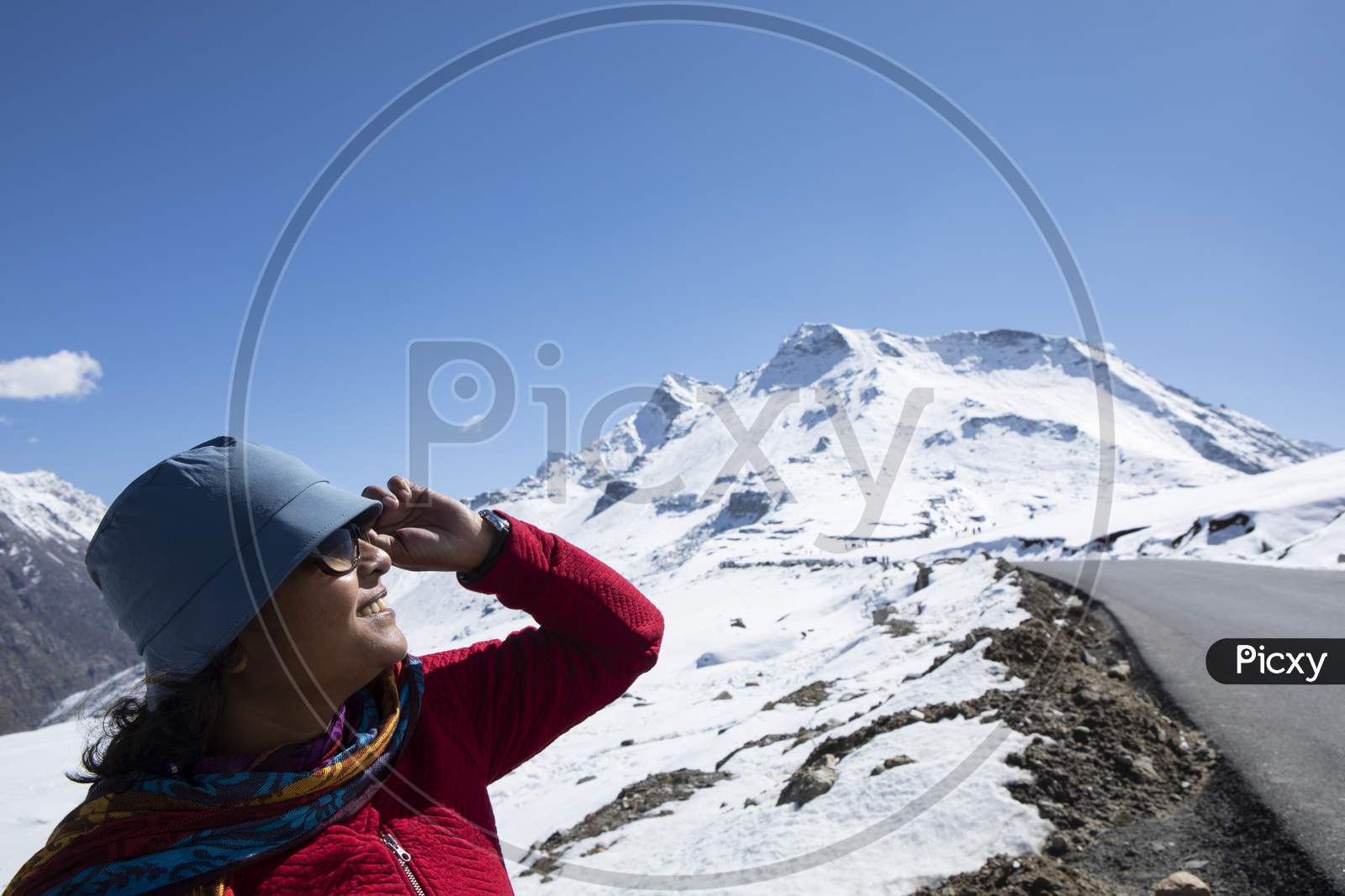 A Beautiful Young Lady With A Red Sweater, A Blue Cap And With Spectacle Enjoying Nature On A Snow Covered High Altitude Pass On Himalaya