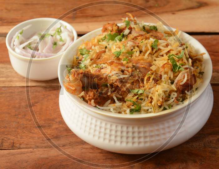 Traditional Hyderabadi Chicken Dum Biryani Made Of Basmati Rice Cooked With Masala Spices, Served With Onion Raita, Selective Focus