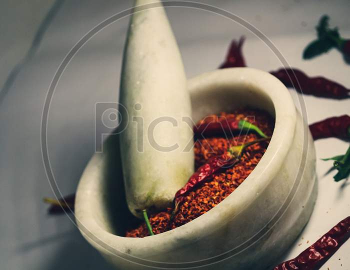 mortar and pestle with red chillies and powder
