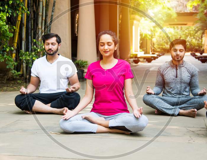 Indian Asian People Doing Yoga Or Meditation Outdoors - Health And Fitness Concept