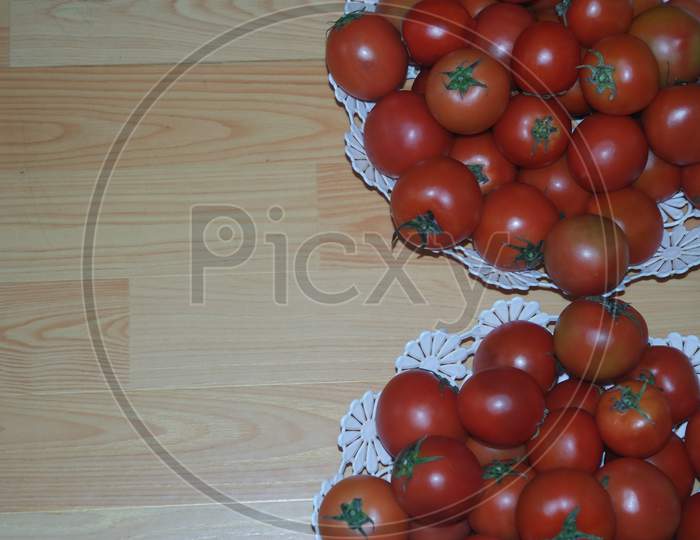 Close-Up View Of Red Tomatoes In White Basket On A Wooden Floor In Market