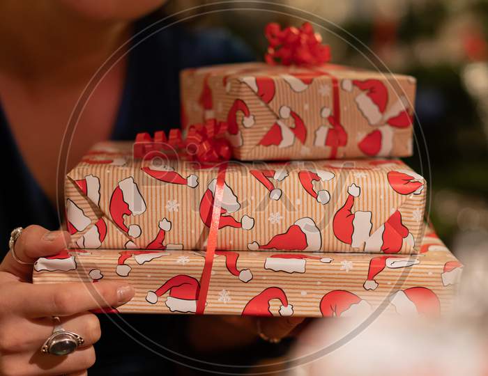 Smiling Girl Giving Gifts In Lovely Boxes With Bird Design At Christmas Eve.