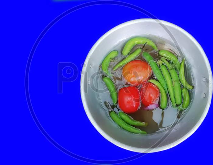 Vegetables Potatoes And Green Chili Peppers In A Bowl Green Background