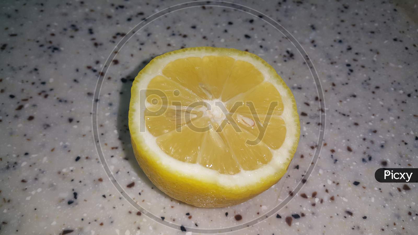 Fresh Lemon Slices With Yellow Peelings Placed On A Grey Floor