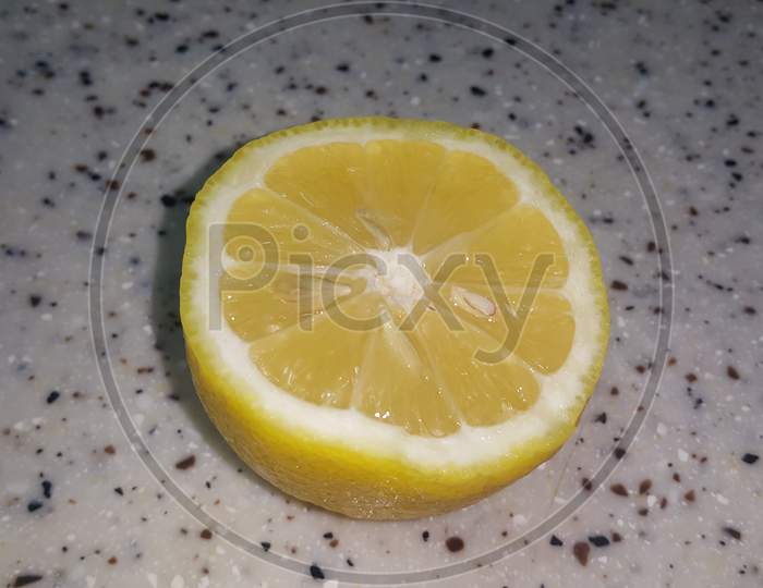 Fresh Lemon Slices With Yellow Peelings Placed On A Grey Floor