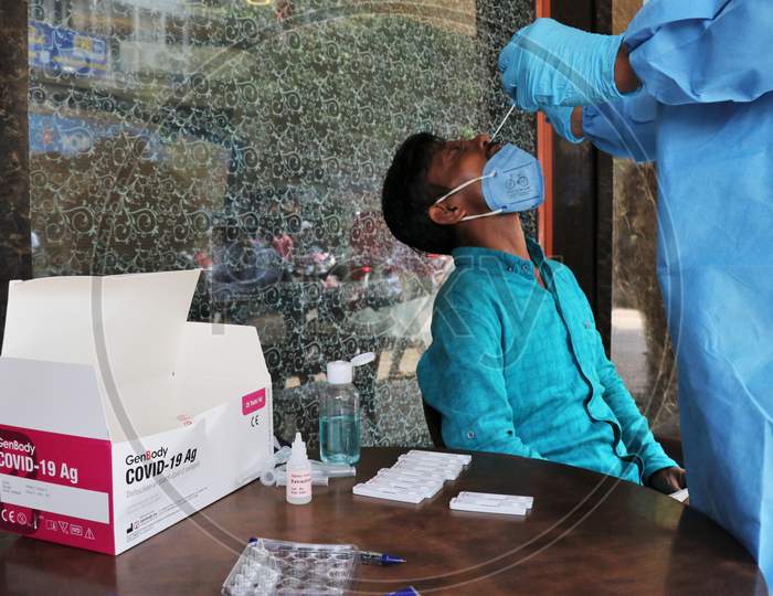 A health worker in personal protective equipment (PPE) collects a swab sample from a man during a rapid antigen testing campaign for the coronavirus disease (COVID-19), on a street in Mumbai, India, November, 2020.