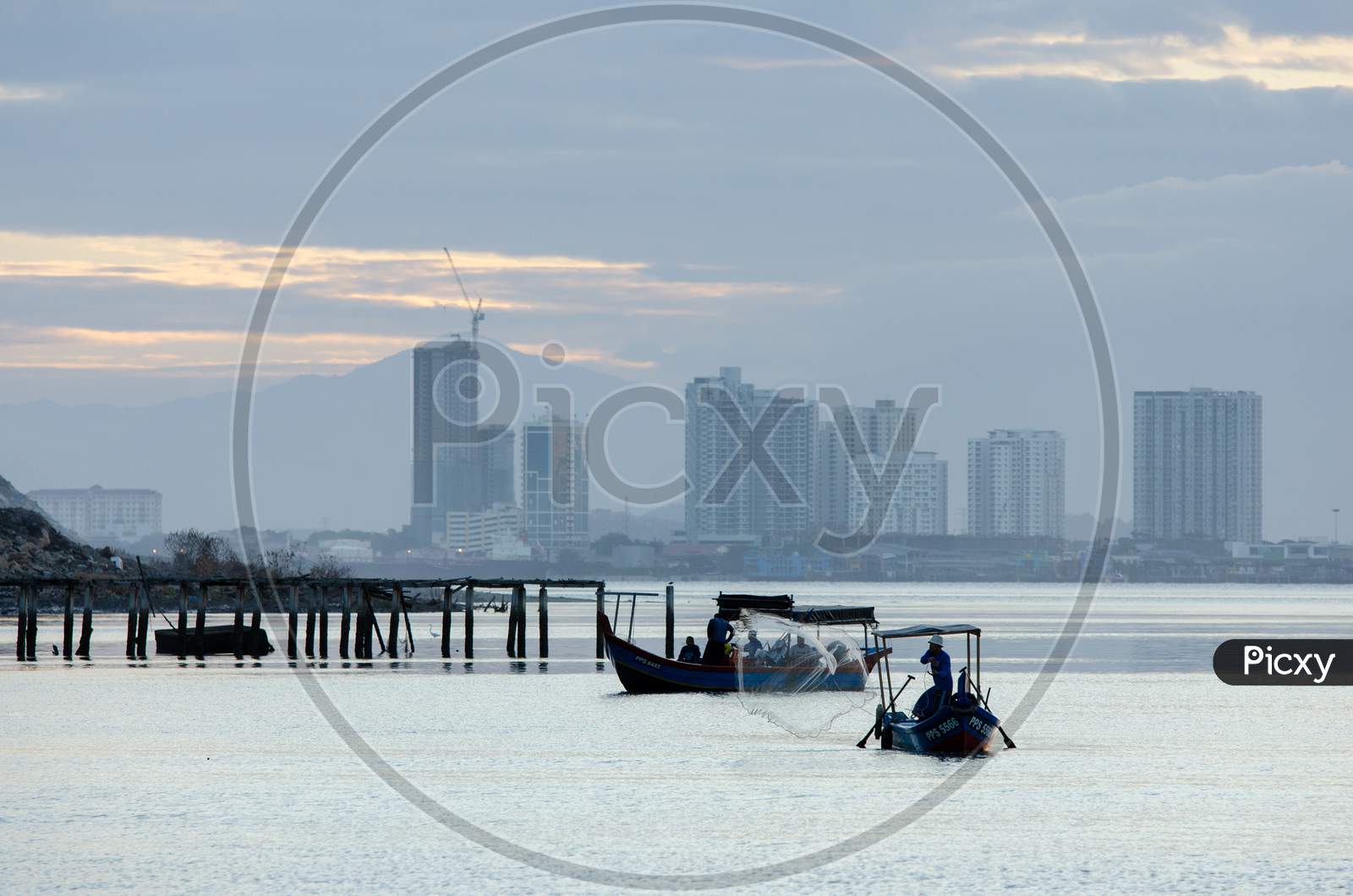A Row Boat Fisherman Cast The Net. Another Boats Is Prepare For Anchoring