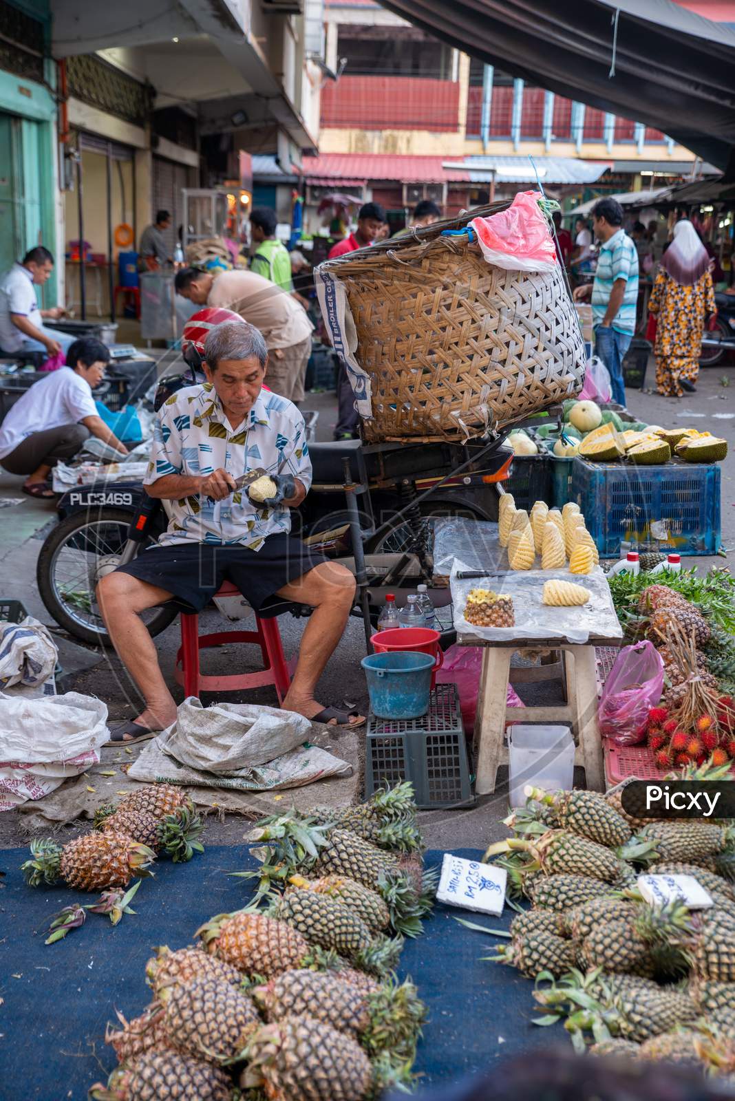 A Chinese Man Sell Pineapple In The Market At Street