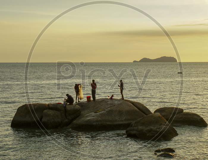 Fisherman Catch Fish On The Large Rock Near Coastal