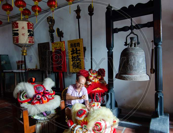 A Old Man Clean The Traditional Chinese Lion Dance Head In The Temple