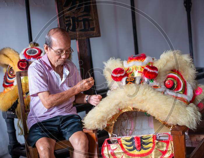 A Man Sew The Lion Dance Head