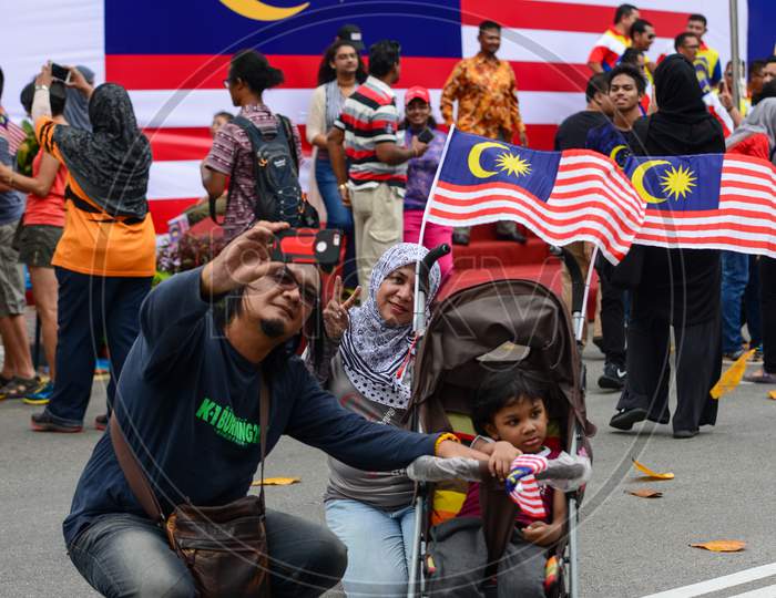 A Man Selfie With Family In Front Of Malaysia Flag After The End Of Independence Parade