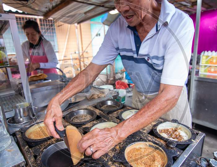 A Man Prepare Apom Balik Food At Market