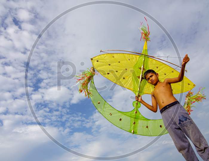 A Local Malays Child Carry Moon Kite Under Blue Sky