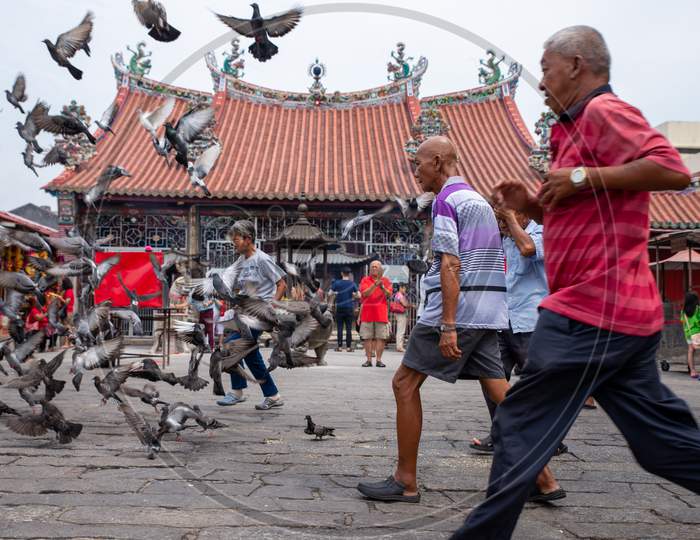 Old Man Run At In Front Of Chinese Temple