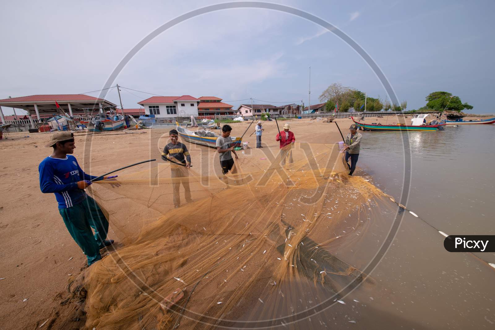 Fisherman Clean Fishing Net Near Beach