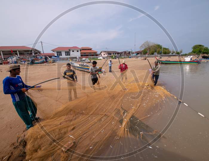 Fisherman Clean Fishing Net Near Beach