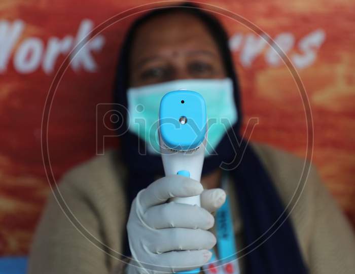 People arriving at a polling station undergo thermal screening during the Fifth phase of the District Development Council (DDC) elections at Phalya Mandal Village outskirts in Jammu .10 Dec.2020.