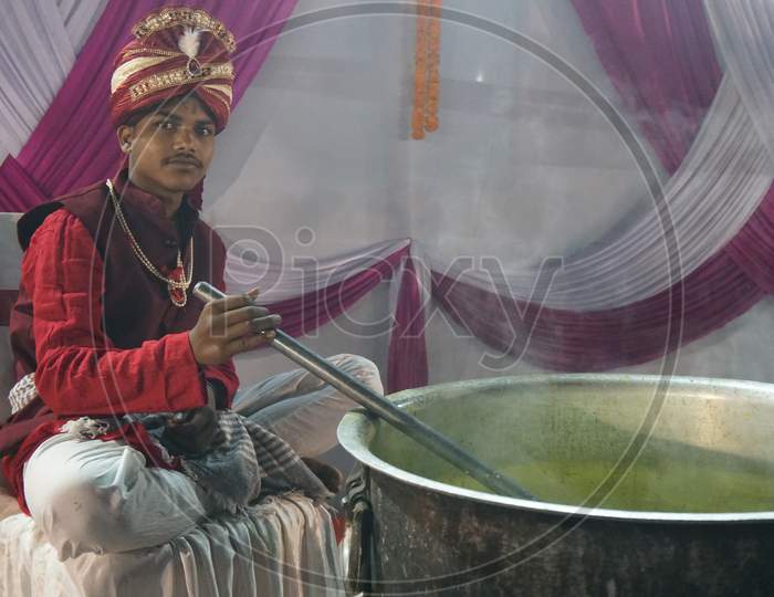 Worker making tea at marriage function in winter.