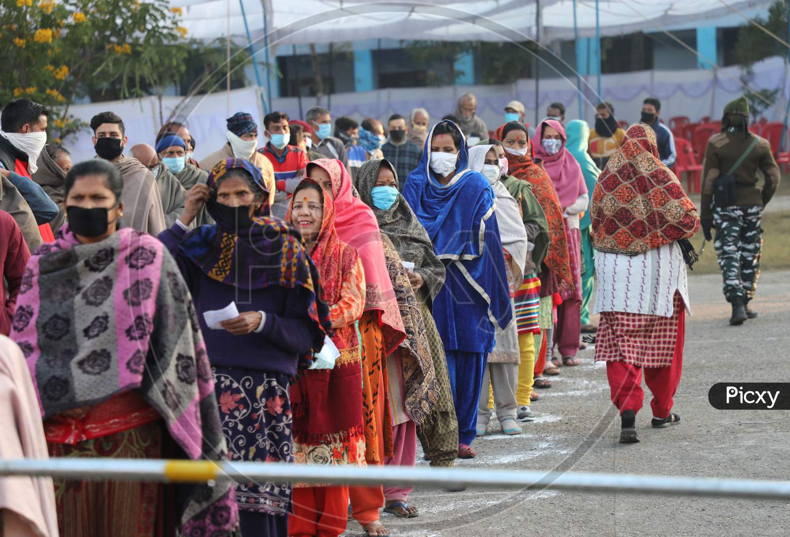 Voters stand in a queue to cast their votes for the Fifth phase of District Development Council (DDC) election, at Phalya Mandal Village outskirts in Jammu.10,Dec,2020.