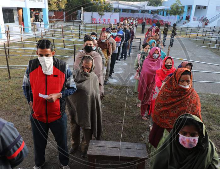 Voters stand in a queue to cast their votes for the Fifth phase of District Development Council (DDC) election, at Phalya Mandal Village outskirts in Jammu.10,Dec,2020.