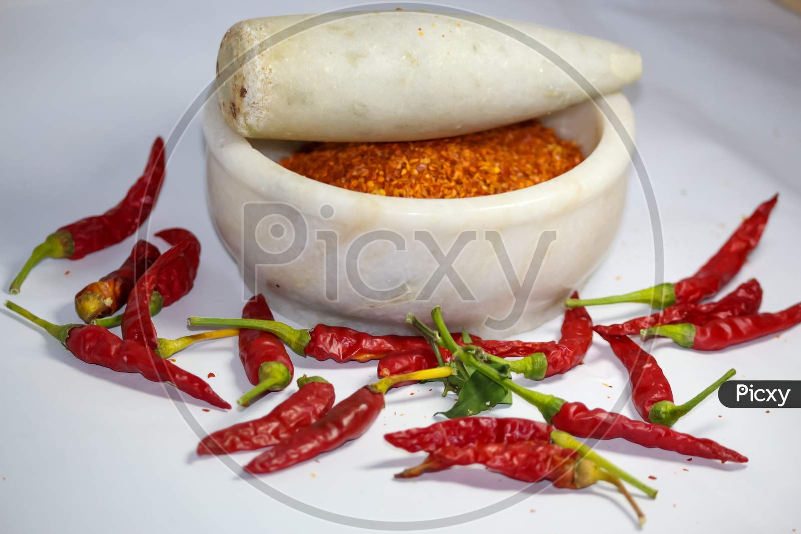red hot chilli peppers and its powder in motor pestle