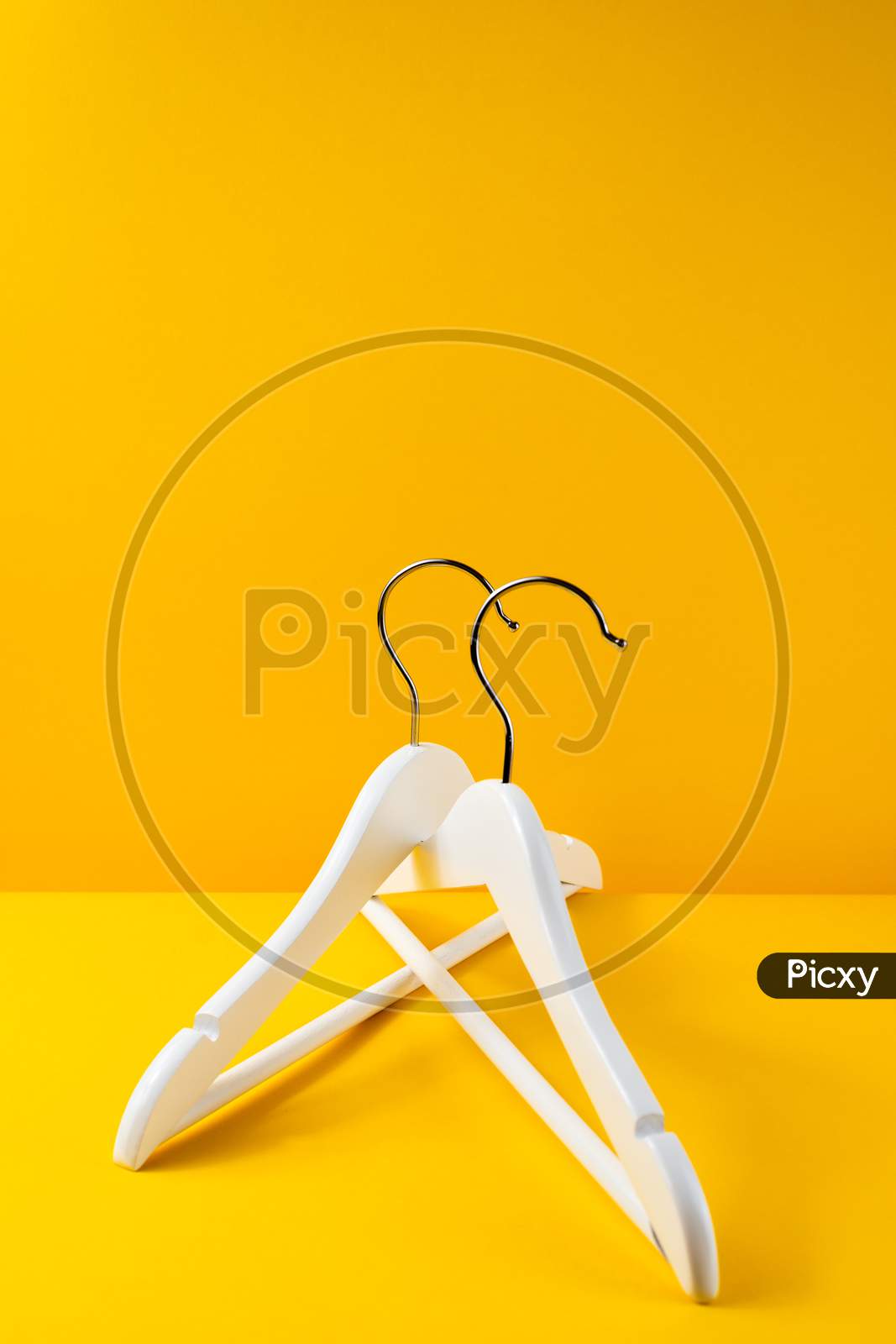 White hangers on a yellow background. Sales clothes concept.