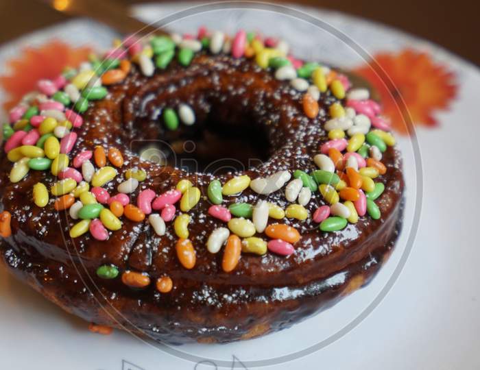 Chocolate donuts sprinkled with colorful topping