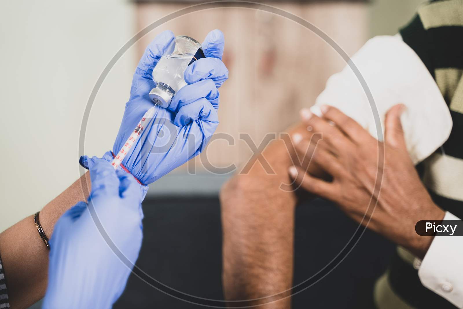 Close up Hands preparing vaccination shot to shoulder of patient - concept of coronavirus or covid-19 vaccine concept.