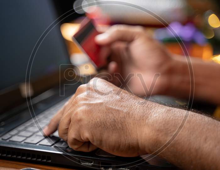 Close Up Of Old Man Hands Busy In Purchasing Or Doing Online Payment On Laptop During Holiday Seasonal Sale - Concept Of Senior People Using Ecommerce, Technology And Internet For Shopping On Laptop.