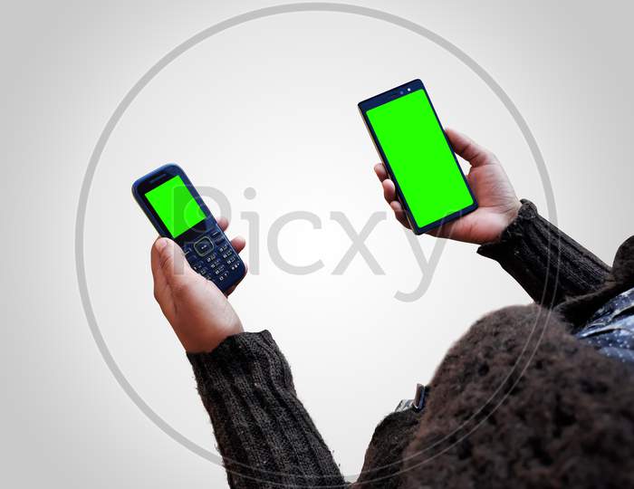Female Holding Two Smart Phones Mock Up In Hands With Green Screen Isolated