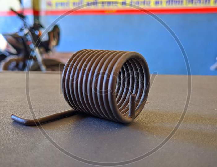 Tension And Compression Spring View Isolated On Wooden Bench.