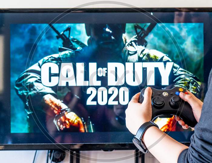 Woman Holding A Xbox Controller And Playing Popular Video Game Call Of Duty On A Television And Pc