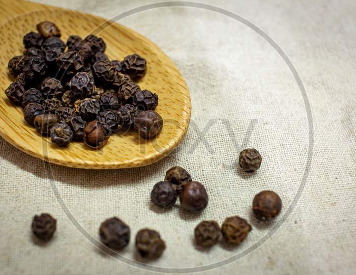 View Of Black Peppercorns In A Wooden Spoon. Black Pepper Boost Immunity Naturally.