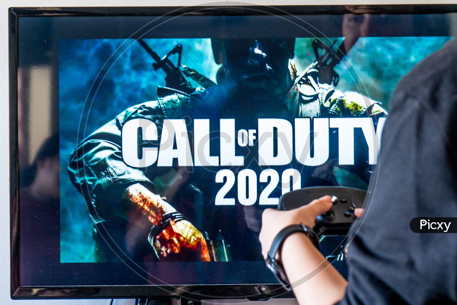Woman Holding A Steam Controller And Playing Popular Video Game Call Of Duty On A Television And Pc