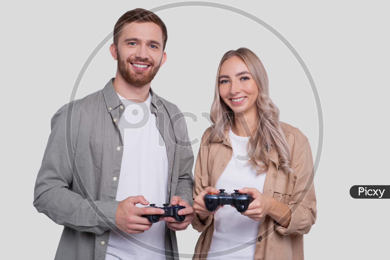Couple Standing With Joysticks In Hands Smilling Isolated