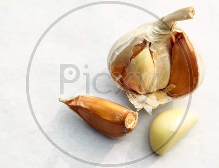 Close-Up Piece Of Dried Garlic And Garlic Bulb On A White Background.Copy Space For Text.