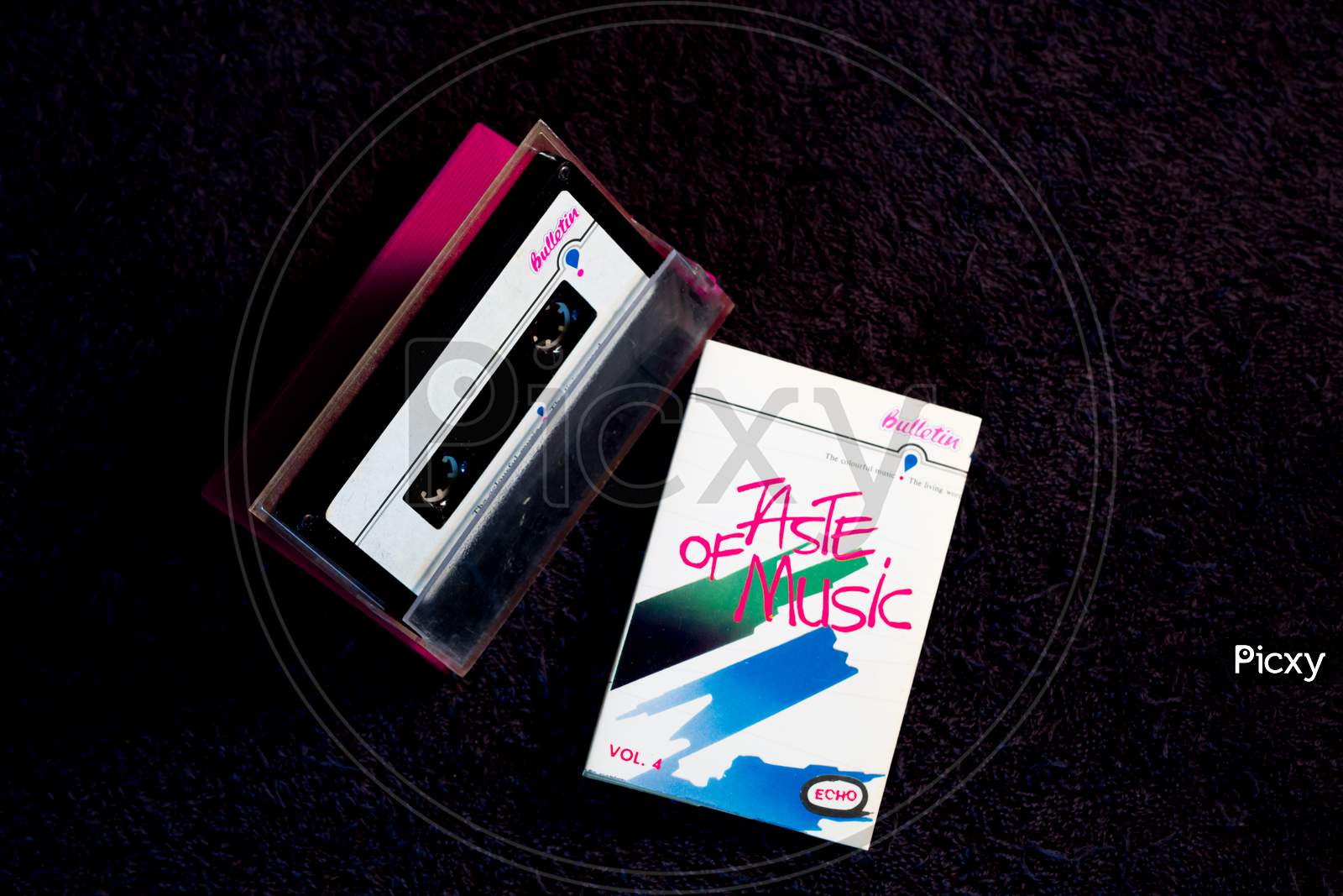 A Pretty picture of a Music Audio Cassette tape with its case against the Black background with a natural light source.