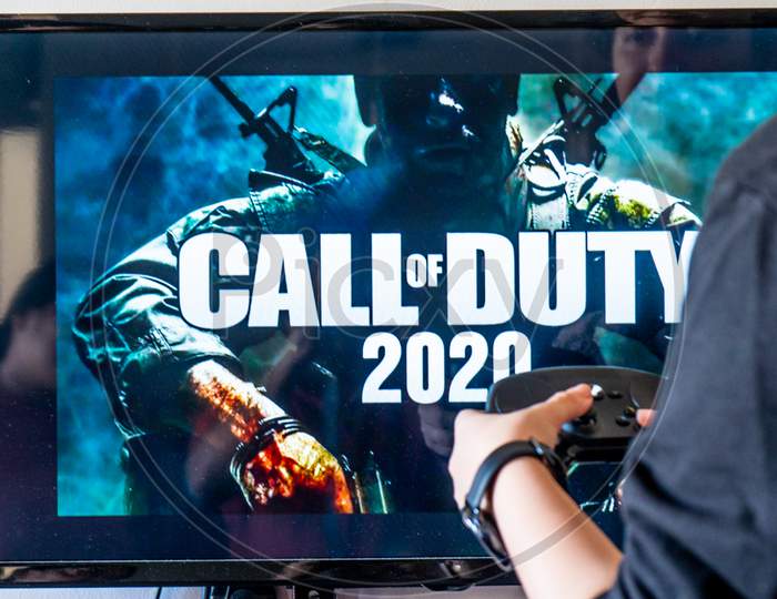 Woman Holding A Steam Controller And Playing Popular Video Game Call Of Duty On A Television And Pc