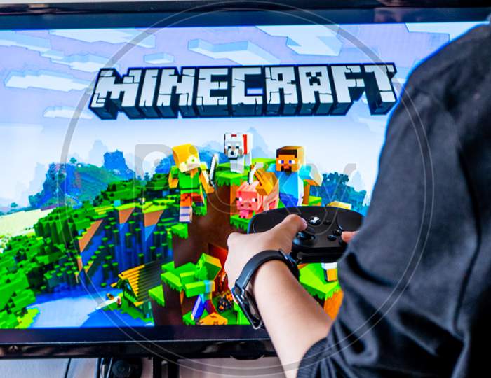Woman Holding A Steam Controller And Playing Popular Video Game Minecraft On A Television And Pc