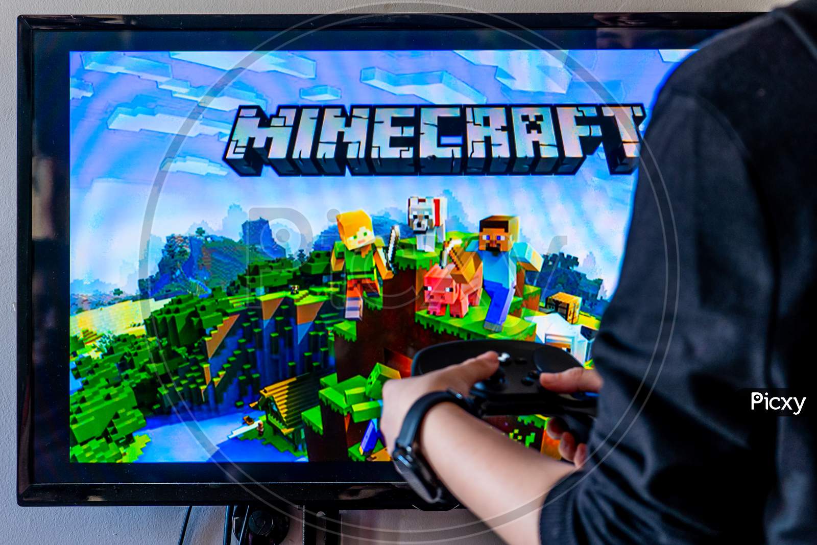 Woman Holding A Steam Controller And Playing Popular Video Game Minecraft On A Television And Pc