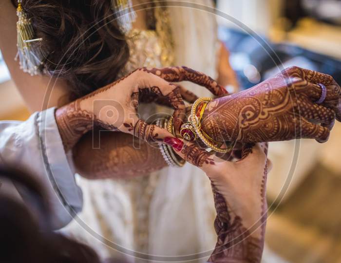 Hand Of An Indian Bride Decorated With Henna Or Mehndi Wearing Gold Bangle Made With Diamond And Red Ruby